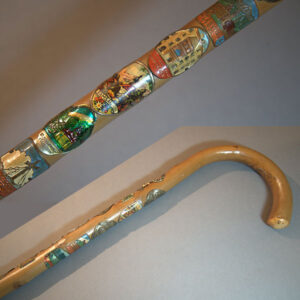 A crook handled hiking cane with 18 badges