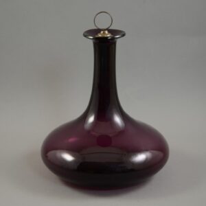 Slightly compressed bulbous decanter of 'Mell' form originating in Scotland in amethyst glass.