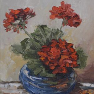 An original oil still life of red geraniums displayed on a table in a blue vase, by artist Mary Champman.